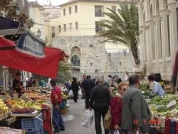 Il mercato di Ortigia, Siracusa: bancarelle, con allo sfondo il Tempio di Apollo